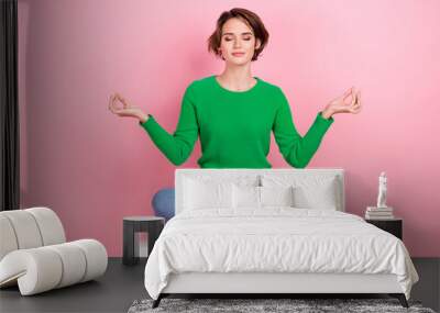 Full length photo of calm adorable girl wear trendy green clothes sitting practicing yoga relax rest isolated on pink color background Wall mural