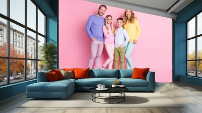 Full length photo of cheerful family with dad daddy mom mommy two kids stand isolated over pink color background Wall mural