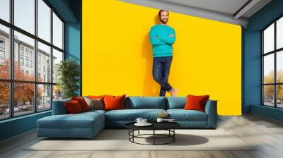 Full length photo of cool cheerful guy dressed teal outfit arms folded smiling isolated yellow color background Wall mural