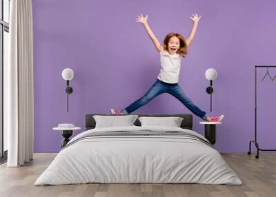 Full length photo of funny small foxy lady jumping high rejoicing making star shape in air cheerful crazy mood wear casual t-shirt jeans isolated purple background Wall mural