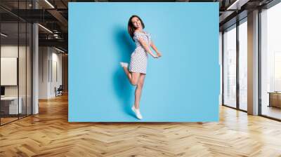 Full length photo of girl jump funny pose palms wear dotted short dress footwear isolated blue color background Wall mural