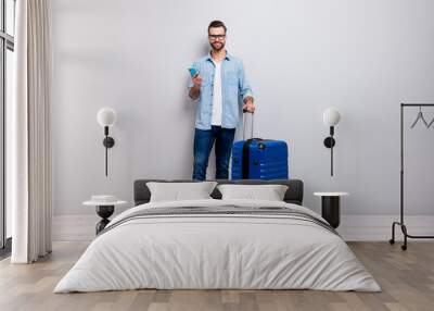 Full length photo of handsome hipster guy holding telephone big tourist bag have student visa europe traveler wear specs denim outfit isolated grey color background Wall mural