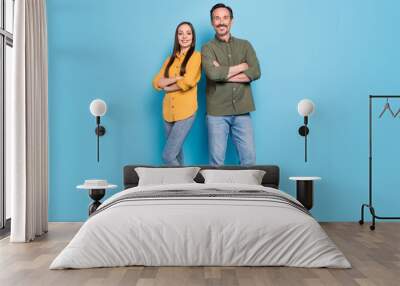 Full length photo of husband wife happy man and woman family married hands crossed isolated on blue color background Wall mural