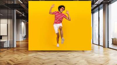 Full length photo of positive excited guy dressed red t-shirt dark glasses dancing having fun isolated yellow color background Wall mural