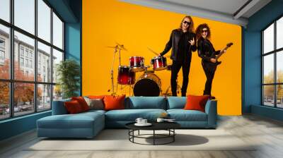 Full length photo popular funky two people punk artist enjoy performance concert girl play bass guitar man hold drumstick show horns symbol wear leather jacket isolated bright color background Wall mural