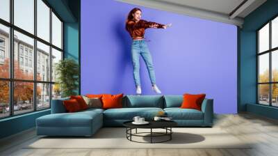 Full length portrait of frightened young woman jump fly empty space wear brown shirt isolated on purple color background Wall mural