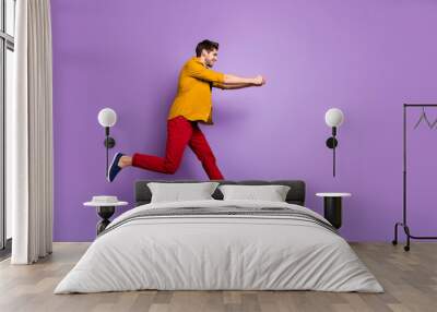 Full length profile side photo of cheerful funky guy jump run hold hand copyspace try pull rope in game wear casual style clothing isolated over violet color background Wall mural