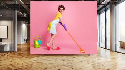 Full length profile side photo of cute maid girl wash floor mop wear dotted dress gloves isolated on pastel color background Wall mural