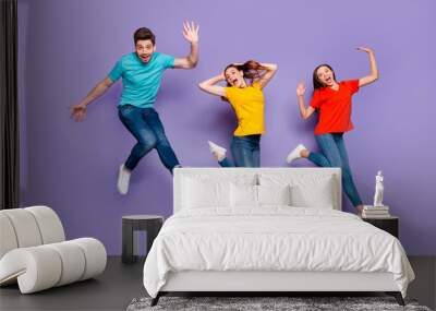 Full length size body photo of two beautiful carefree cheerful excited ladies and one comic funny in blue t-shirt guy waving hand saying hello isolated violet background Wall mural