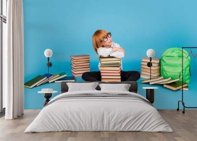 Full size photo of small schoolkid boy hold book look empty space wear uniform isolated on blue color background Wall mural