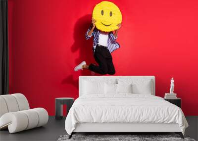 Full size photo of young black man jump up cover face figure smile isolated over red color background Wall mural