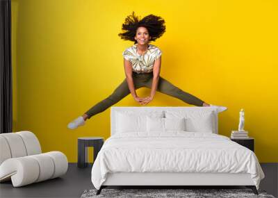 Full size photo of young excited afro girl have fun jump up energetic isolated over yellow color background Wall mural