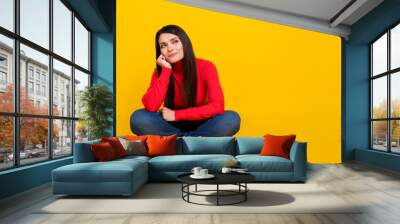 Full size portrait of pretty positive lady arm on cheek look interested empty space isolated on yellow color background Wall mural