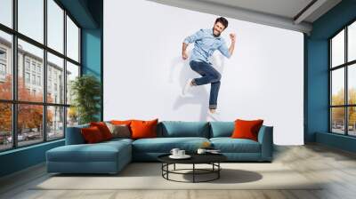 Full size profile photo of funny indian guy jumping high rejoicing raising fists crazy competitive mood wear casual denim clothes isolated white color background Wall mural