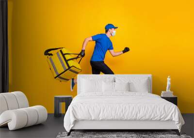 Full size profile photo of running deliveryman wear medical safety mask gloves isolated on yellow color background Wall mural