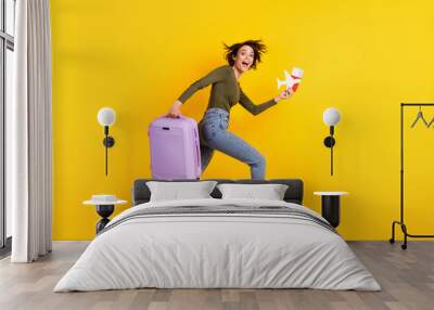 Full size profile side photo of crazy girl jump run fast with luggage plane visa isolated on shine yellow color background Wall mural