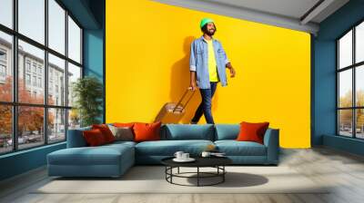 Full size profile side photo of young happy cheerful afro man look copyspace go with baggage isolated on yellow color background Wall mural