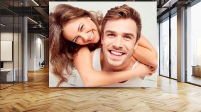 Happy cute girl in love at home embracing boyfriend Wall mural