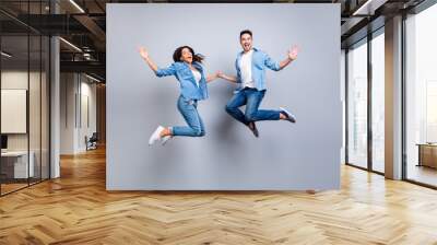 He vs She full length portrait of attractive, playful, cheerful, hispanic couple in casual outfit jumping with opened mouths over grey background Wall mural