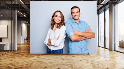 He vs she happy together. Close up portrait of attractive, caucasian, lovely, cute, adult couple in casual outfit  looking at camera standing with crossed arms over grey background Wall mural