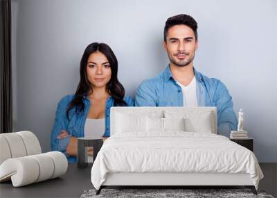 He vs She portrait of caucasion hispanic couple in jeans shirt - man with bristle and pretty, attractive woman with crossed hands standing over grey background Wall mural