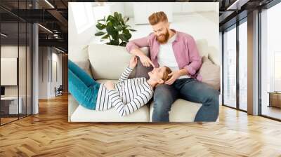 Look romance chill wife husband vacation weekend holidays concept. Handsome peaceful cheerful stylish trendy guy and beautiful cute lovely joyful girl having a rest in new flat lying on beige divan Wall mural