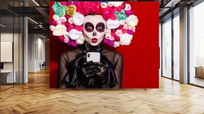 Photo dead bride demon lady send kiss folklore religion face paint telephone blogging death day theme mexican culture floral headband black costume isolated red color background Wall mural