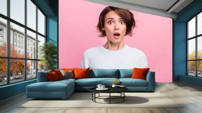 Photo of amazed shocked young woman afraid scared problem bad mood astonished isolated on pink color background Wall mural