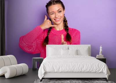 Photo of attractive positive woman wink eye point you make call me sign isolated on purple color background Wall mural