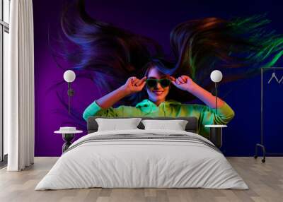 Photo of attractive stunning young girl wear sunglass long hair fly isolated on neon colorful color background Wall mural