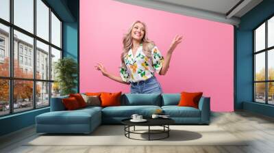 Photo of attractive young girlfriend blonde wavy hair dancing choose new spring outfit looking novelty isolated on pink color background Wall mural