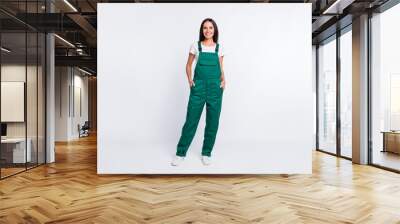 Photo of charming cool lady hands pockets look camera wear green overall isolated white color background Wall mural