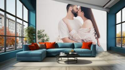 Photo of cheerful cute young couple enjoy weekend couple wife husband hugging kissing buy new apartment indoors inside house home Wall mural