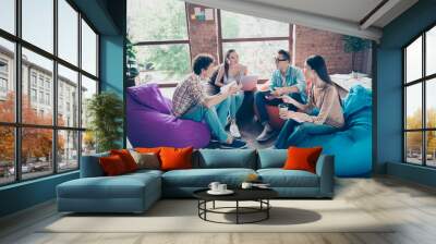 Photo of cheerful funny workers group sitting dorm discussing new study program indoors workplace workshop Wall mural