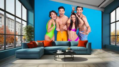 Photo of cheerful girls guys have fun enjoy summer time vacation on resort isolated blue color background Wall mural