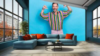 Photo of cheerful man wear trendy vintage bright colorful clothes recommend choose buy new collection isolated on blue color background Wall mural