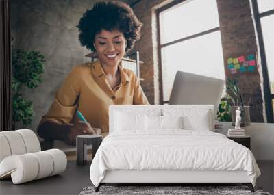 Photo of cheerful pretty cute nice girlfriend having been employed to job as executive smiling toothily sitting at desktop with laptop noting down important information Wall mural