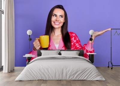 Photo of cheerful pretty lady dressed pink cardigan drinking tea showing arm empty space isolated violet color background Wall mural