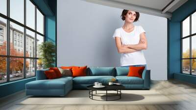 Photo of confident dreamy woman dressed white t-shirt arms crossed looking empty space isolated grey color background Wall mural