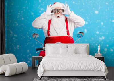 Photo of crazy stylish fat santa claus impressed x-mas christmas magic drive style trendy scooter wear goggles touch hands suspenders overalls cap isolated over blue color background Wall mural