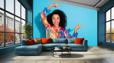 Photo of curly hair woman in trendy sweatshirt index fingers summer shopping propaganda proposition isolated on blue color background Wall mural