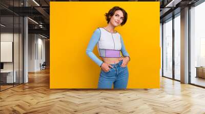 Photo of cute dreamy woman wear top looking empty space smiling isolated yellow color background Wall mural