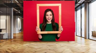 Photo of cute lovely lady hairdo arms hold photo frame take remember portrait wear trendy green outfit isolated on vivid red color background Wall mural