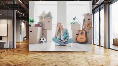 Photo of doubtful unsure young girl wear jeans shirt creating packing list ready moving indoors house room Wall mural