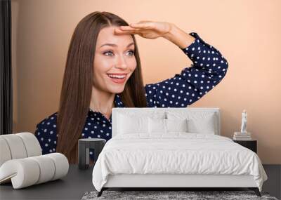 Photo of dreamy funny young lady wear blue shirt arm forehead looking far away empty space isolated beige color background Wall mural