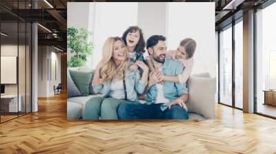 Photo of four family members spend time rejoicing giggle piggy back position sit couch living room Wall mural