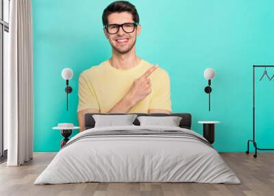 Photo of funny brunet young guy index promo wear eyewear yellow t-shirt isolated on turquoise color background Wall mural