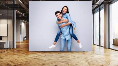 Photo of funny guy and lady holding piggyback playing leisure game rejoicing wear casual jeans clothes isolated grey color background Wall mural