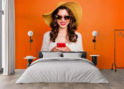 Photo of funny lady summer time holding telephone sending best friend photos from tropical ocean resort wear sun hat specs stylish beach cape isolated orange background Wall mural