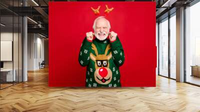 Photo of funny santa man with pretty horns on head celebrating newyear surprise visit from children wear stylish x-mas ugly ornament sweater isolated red background Wall mural